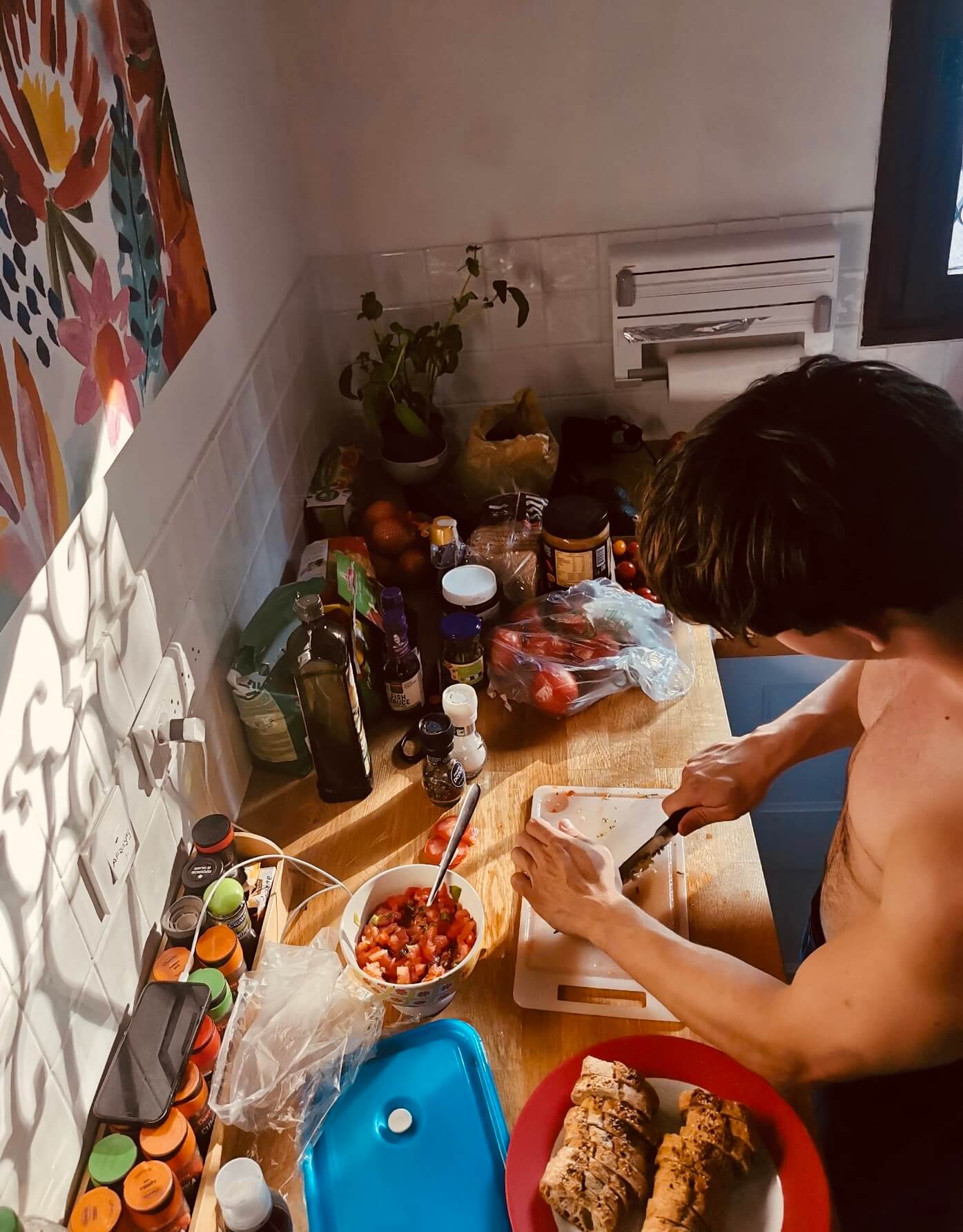 A shot from above where you can see me cutting garlic while I am cooking in a colorfull kitchen.